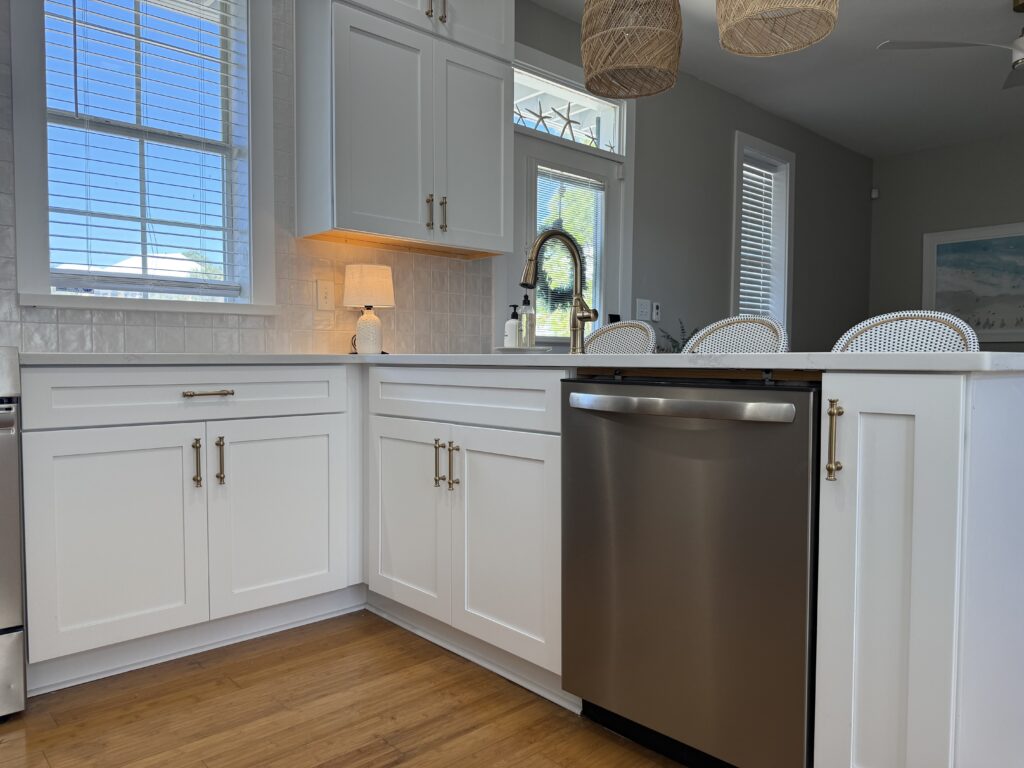 Wellborn Saybrook bright white kitchen featuring lower cabinets on the peninsula with a dishwasher and sink