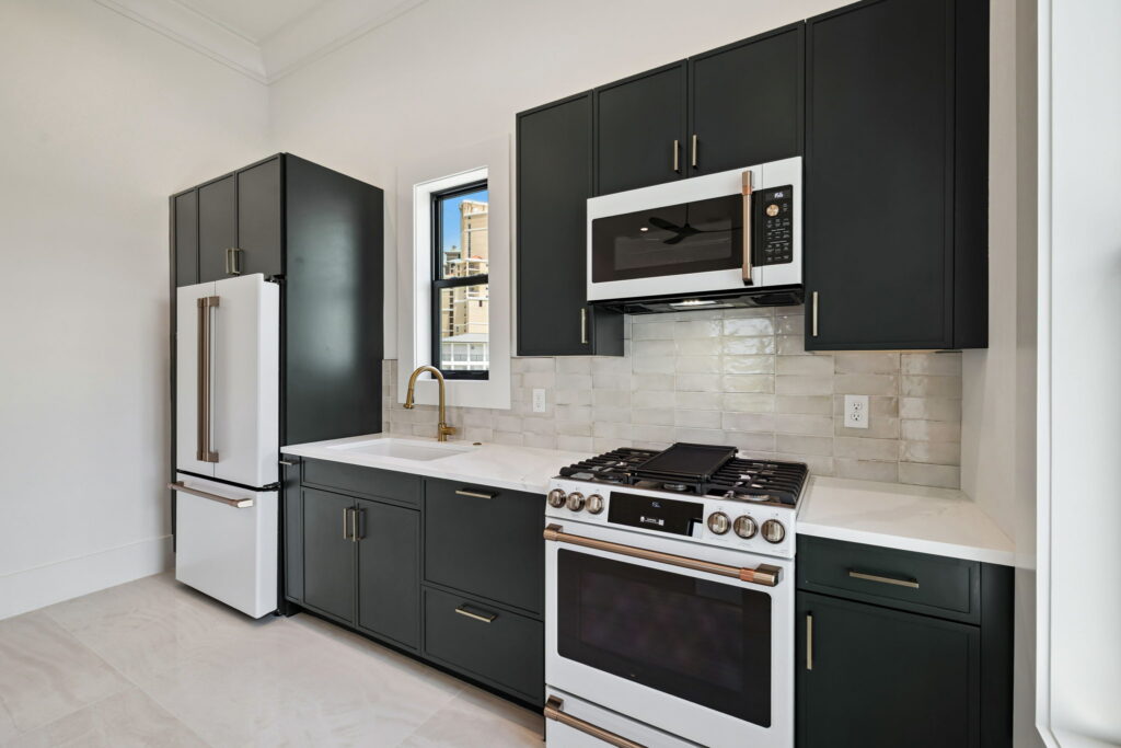 Modern kitchen with black cabinets and white appliances
